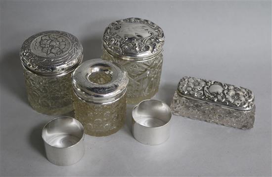 Three silver topped bottles, a jar and two napkin rings.